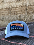 Load image into Gallery viewer, This hat is both well-made and comfortable to wear that features the first patch we ever designed! It represents the horses we feed, and the landscape we live in.