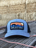 Load image into Gallery viewer, This hat is both well-made and comfortable to wear that features the first patch we ever designed! It represents the horses we feed, and the landscape we live in.